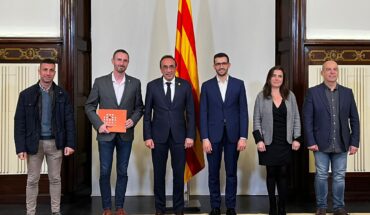 Els membres de la junta permanent i el director del Fons Català amb Josep Rull al centre posant per una fotografia amb la bandera de catalunya al darrere